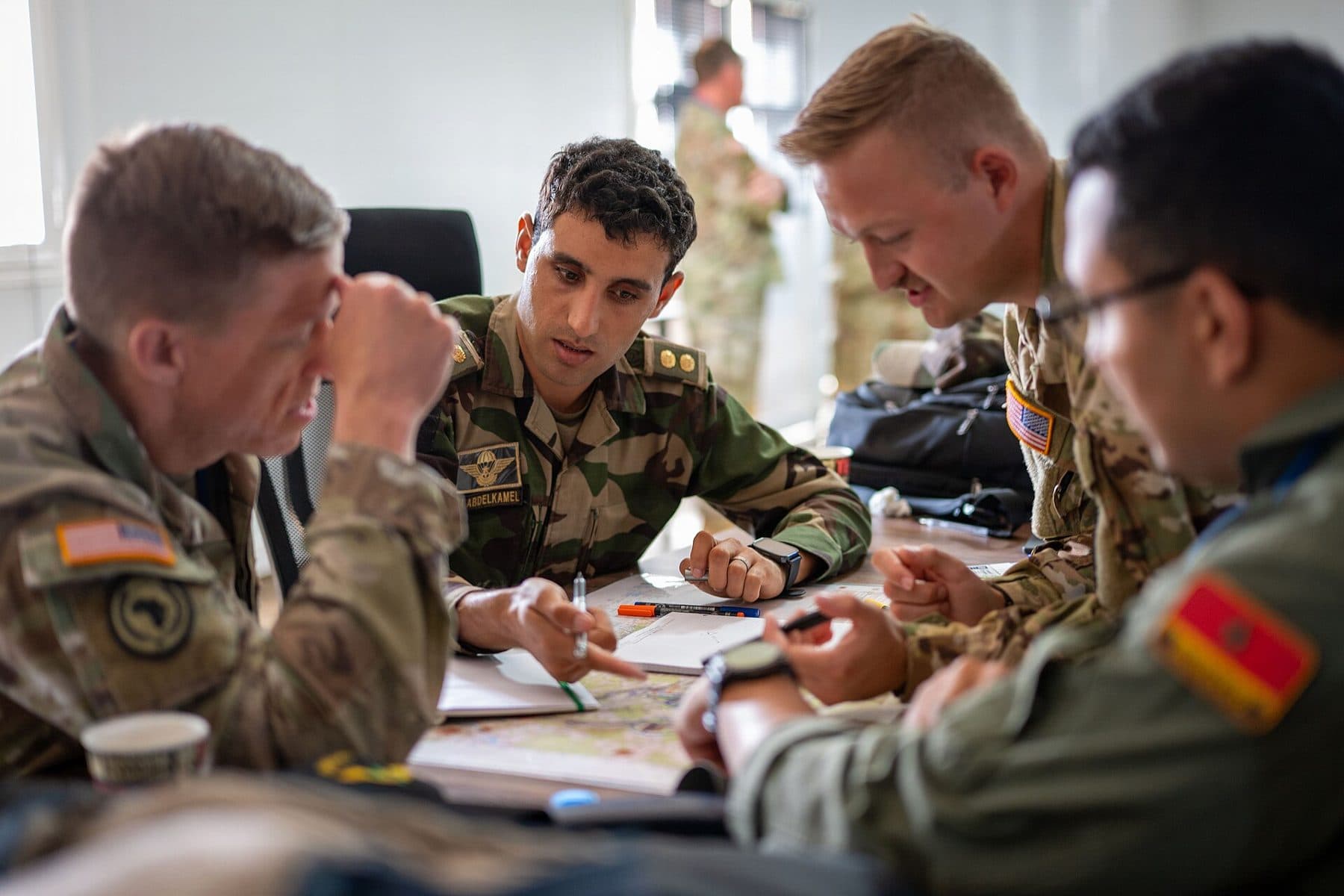 Service members plan around a table, representing defense tech advisory and strategy